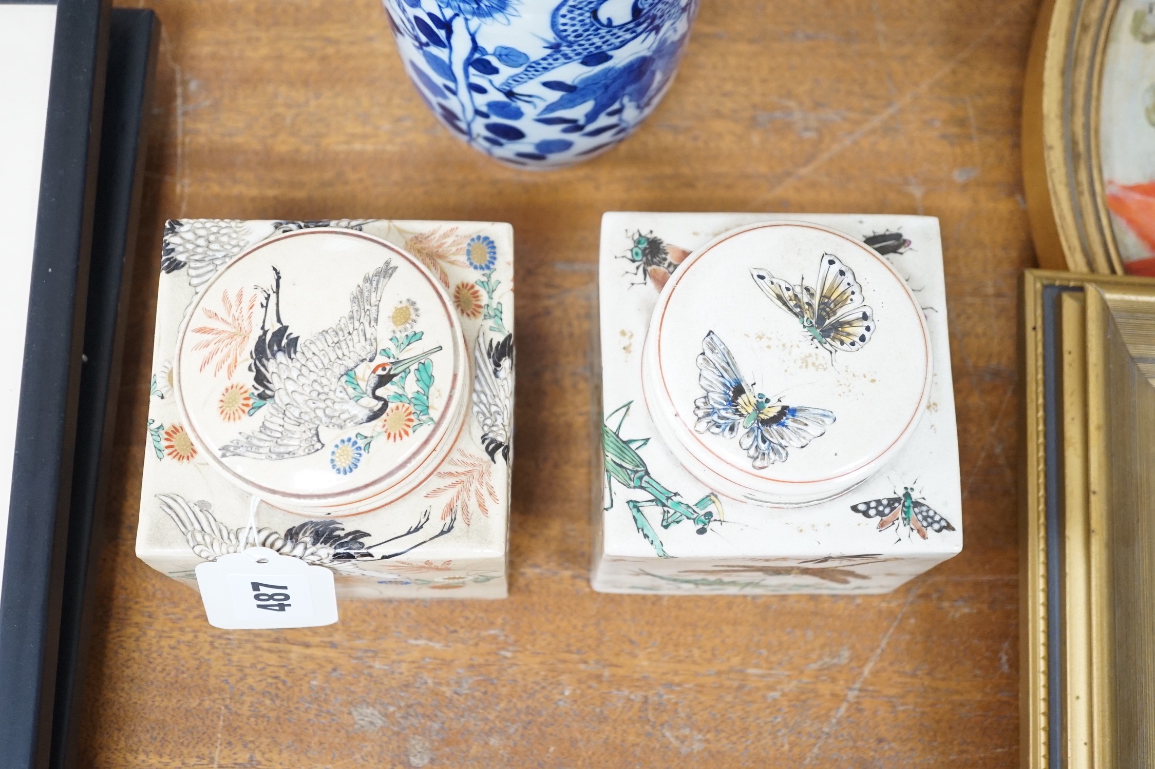 Two Japanese Satsuma boxes and covers, 10cm wide, and a blue and white Chinese vase, 26cms high